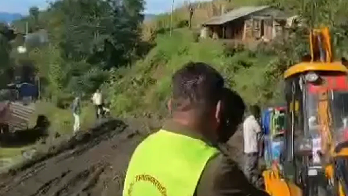 साँघुरो हिलाम्मे पहाडी सडकछेउ एक्साभेटर र फिल्ड कामदारहरू।